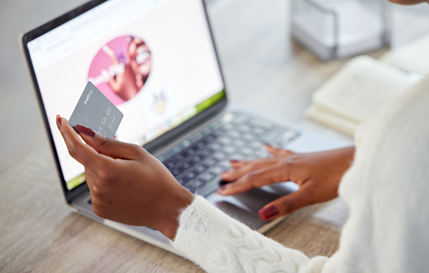 Shot of an unrecognisable woman using a laptop and credit card while working at home